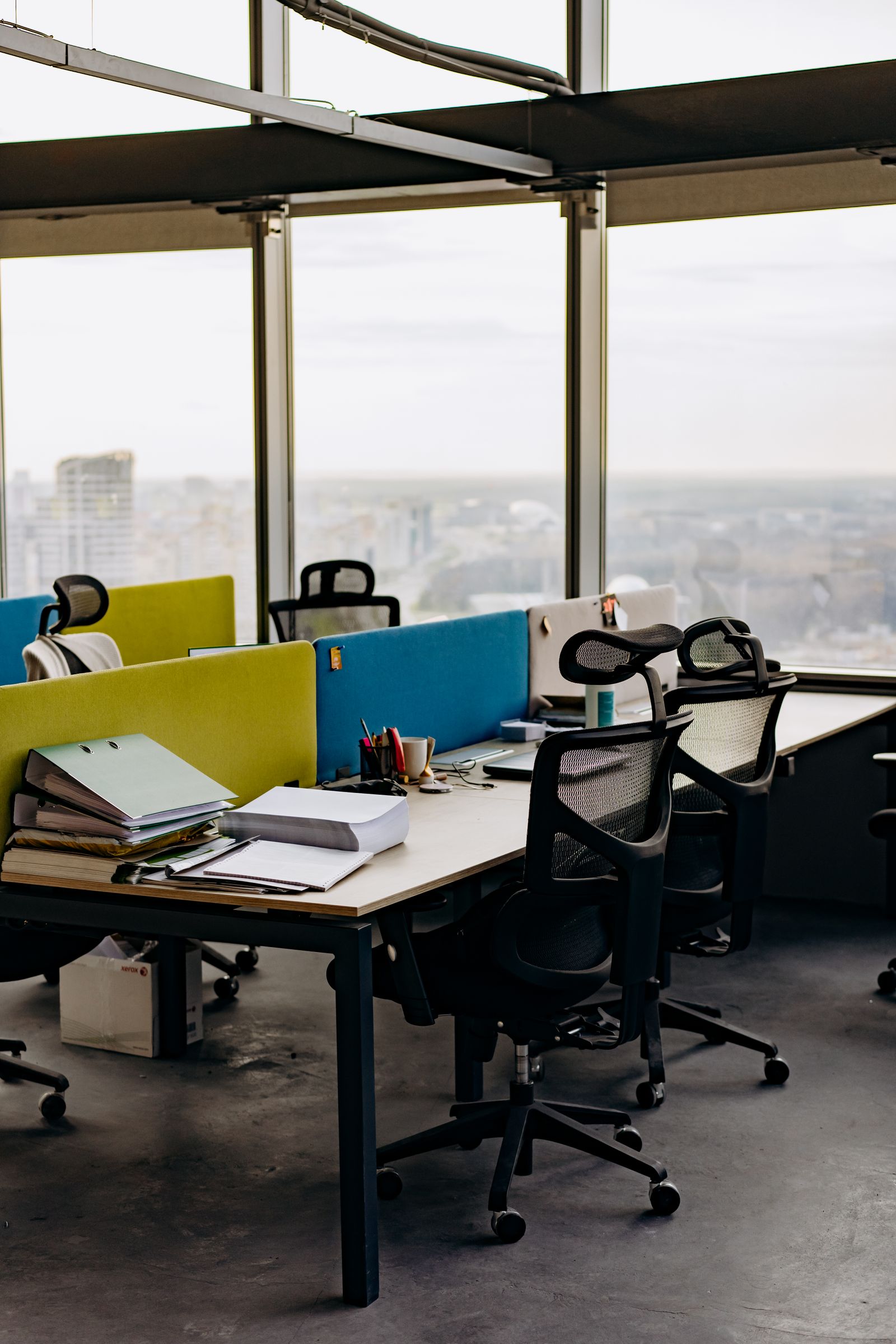 Flexible coworking workspace with desk dividers and city view