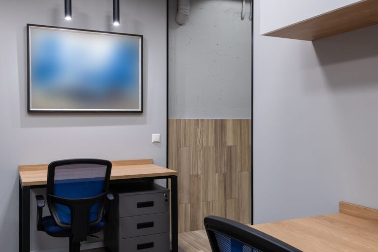 Modern minimalist office workspace with desk and presentation screen