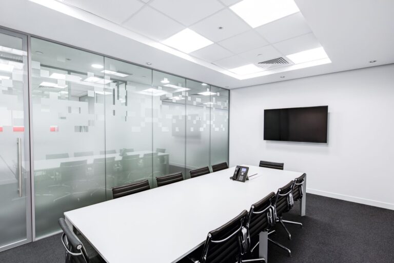 Sleek glass-walled conference meeting room with long table